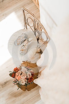 Wedding shoes and wedding bouquet on the chair