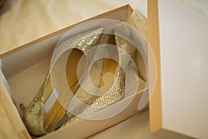 Wedding shoes in a white box on the floor