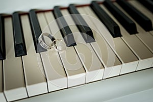 Wedding silver rings lying on the piano keys