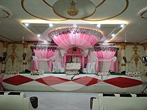 Wedding stage, beautiful interior design, flowers for decoration and pink dominates in colours of decoration