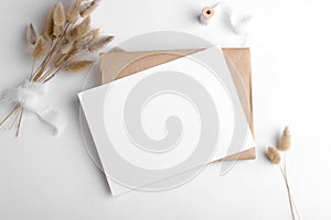 Wedding stationery invitation card mockup 7x5 on white background with envelop and boho decor photo