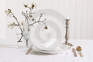 Wedding stationery mock-up. Blank business, RSVP paper card on plate. Festive table setting with brass candleholder photo