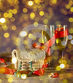 Wedding still life with champagne glasses rings and a box with gifts bokeh gold