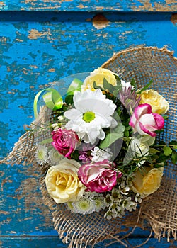 A wedding story or background Mother`s Day. Basket bouquet of roses and chrysanthemums on a vintage wooden background.