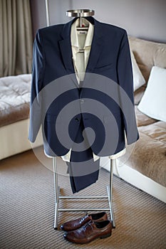 Wedding suit, shirt, trousers, shoes of groom hanging on hanger