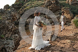 Wedding on the sunset with live floristry. Bride and groom in boho style.