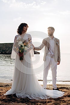 Wedding on the sunset with live floristry. Bride and groom in boho style.