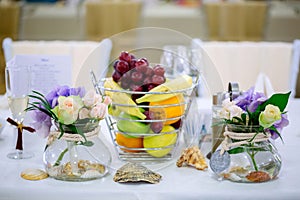 Wedding table arrangement with flower bouquets and fruit basket