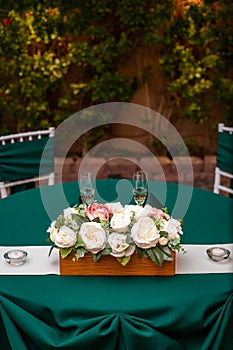 Wedding Table for couple with a white and peach rose floral arrangement and two filled champagne glasses