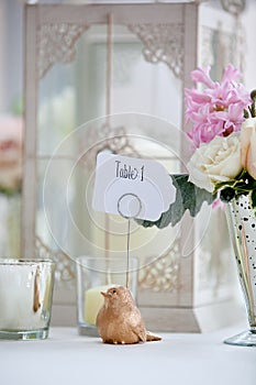 Wedding table decoration series - pink and white bouquet of flowers and a bird holding a table 1 sign photo