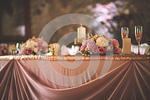 Wedding table with exclusive floral arrangement prepared for reception, wedding or event centerpiece in rose gold color