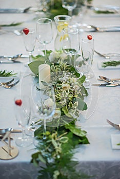 Wedding table with exclusive floral arrangement prepared for reception, wedding or event centerpiece in greenery style