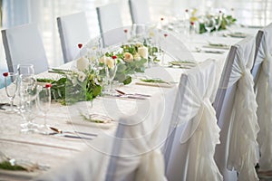 Wedding table with exclusive floral arrangement prepared for reception, wedding or event centerpiece in greenery style