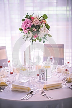 Wedding table with exclusive floral arrangement prepared for reception, wedding or event centerpiece in romantic pink style