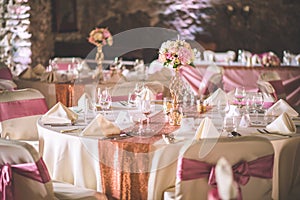 Wedding table with exclusive floral arrangement prepared for reception, wedding or event centerpiece in rose gold color