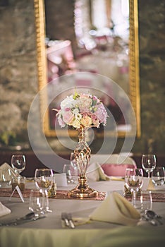Wedding table with exclusive floral arrangement prepared for reception, wedding or event centerpiece in rose gold color