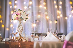 Wedding table with exclusive floral arrangement prepared for reception, wedding or event centerpiece in rose gold color photo