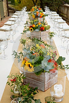 Wedding table flower decorations in wooden boxes.