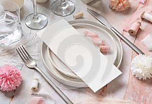 Wedding Table place with a card near pink flowers, feathers and silk ribbons, menu mockup