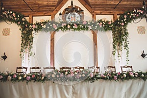 wedding table in the restaurant with a lot of transparent glasses, napkins and decoration of dishes.