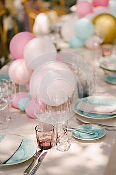 Wedding table setting. Banquet table decoration with balls. Wedding dinner table with blue plates, glasses, forks