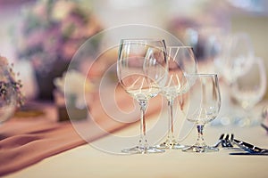 Wedding table setting. Beautiful table set with flowers and glass cups for some festive event, party or wedding reception