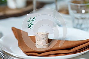 Wedding table setting with blank guest card on a dish. Rustic de