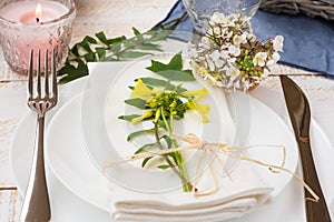 Wedding table setting, elegant, white yellow flowers, green leaves, candle, plates, blue napkin, wood table, outdoors, kinfolk, r