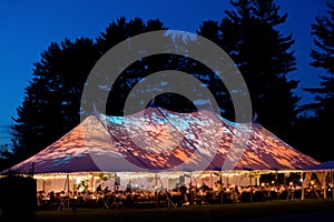 Wedding tent at night - Special event tent lit up from the inside with dark blue night time sky and trees