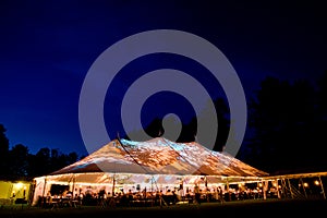 Wedding tent at night - Special event tent lit up from the inside with dark blue night time sky and trees