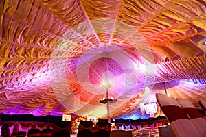 A wedding tent at night surrounded by trees with an orange glow from the lights, long exposure - wedding tent series