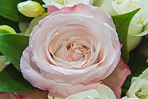 Wedding, Valentine`s day. Beautiful delicate wedding bouquet white and pink roses, wedding rings of the bride and groom