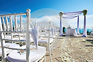 Wedding venue setting on the hill, arch and altar decoration, white chairs with cone of rose of petals
