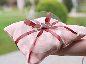 Wedding white gold rings on pink pillow