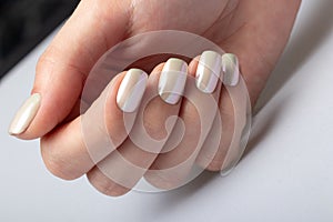 Wedding white pearl manicure on short square nails on a white background close-up