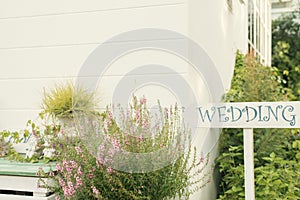 Wedding Wood Sign against the green blur background. Wooden signboard with the inscription in white paint wedding.