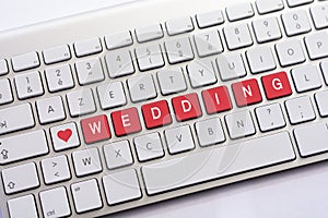 WEDDING writing on white keyboard with a heart sketch