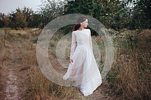 Wedding. Young beautiful bride with hairstyle and makeup posing in white dress.