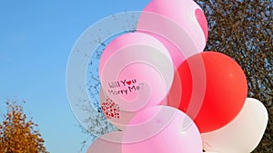 Weddings. Air balloons with words - Will you marry me. Air-balloons over blue sky background. Decor for wedding