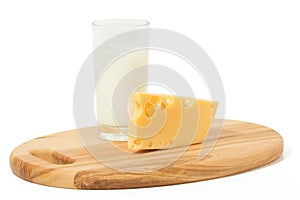 Wedge of cheese and glass of milk on a cheese board