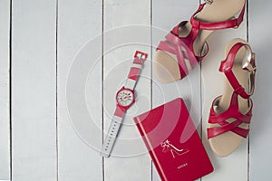 A wedges shoes, a book and a wristwatch in red theme