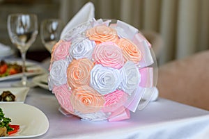 Weding bouquet on a table. Close up photo of beautiful ideal perfect charming orange white and pink silk fabric small wedding brid