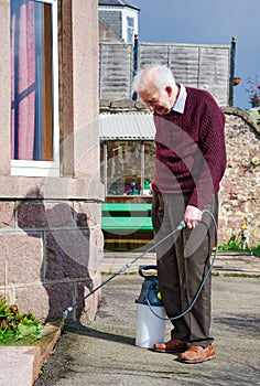 Weed killer spray using pump action bottle in garden