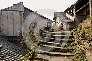 Weedy stone steps before abandoned houses in ancient town