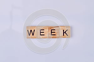Week word made with wooden cubes and black letters.