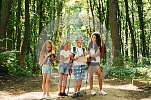 Weekend activies. Kids strolling in the forest with travel equipment