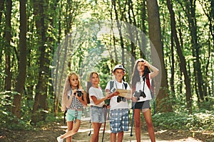 Weekend activies. Kids strolling in the forest with travel equipment