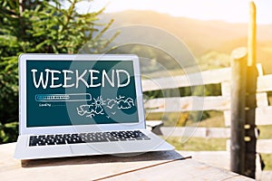 Weekend coming soon. Laptop on wooden table in mountains