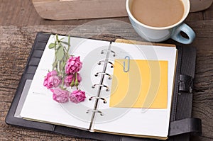 Weekend concept. Pink rose, mug with coffee, diary and stcky not