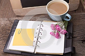 Weekend concept. Pink rose, mug with coffee, diary and stcky not